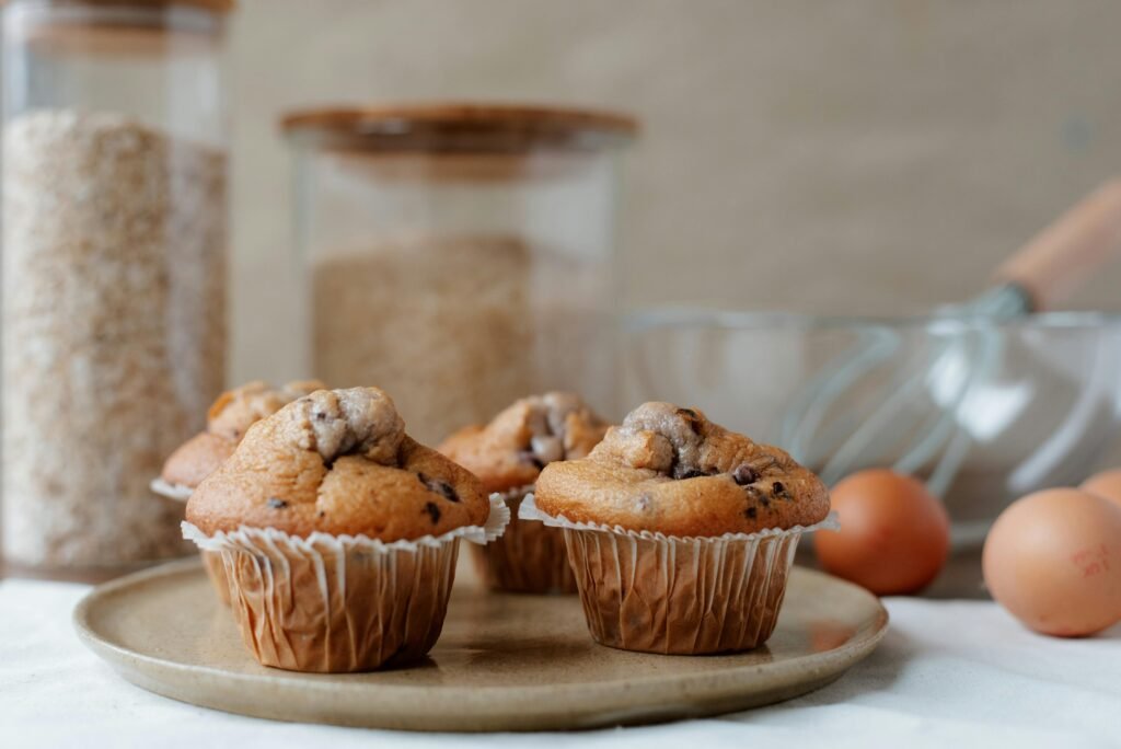 Freshly baked chocolate chip muffins displayed on a plate, perfect for breakfast or dessert.